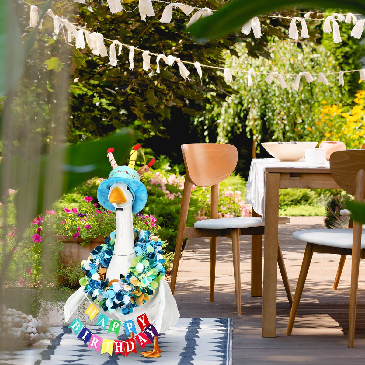 Abbylike Blue birthday costume on goose statue brightens garden celebrations.
