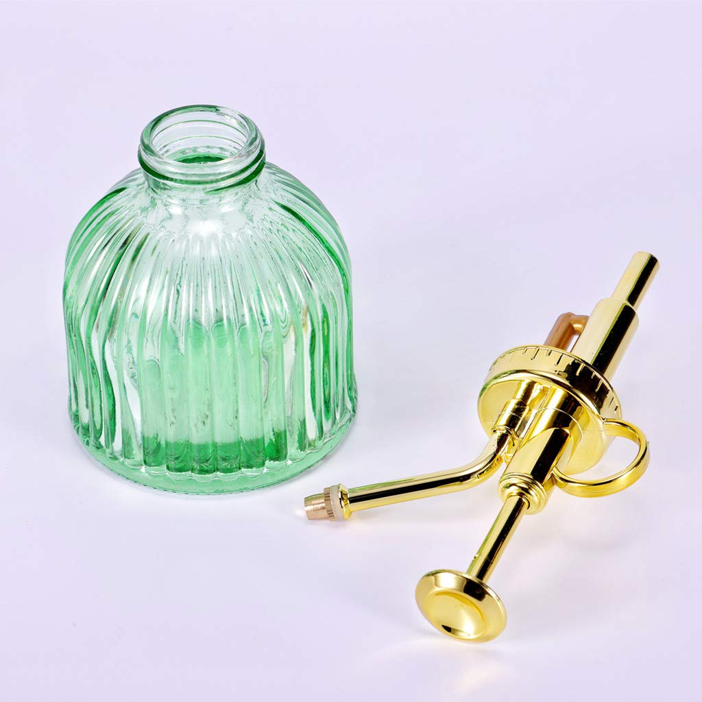 Aebor green glass spray bottle adds decorative appeal near plants.