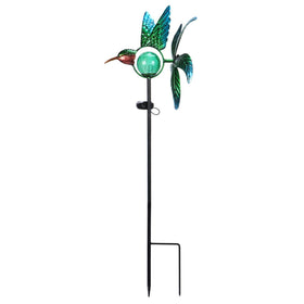 Afirst solar hummingbird wind spinner glows at night while turning in daylight