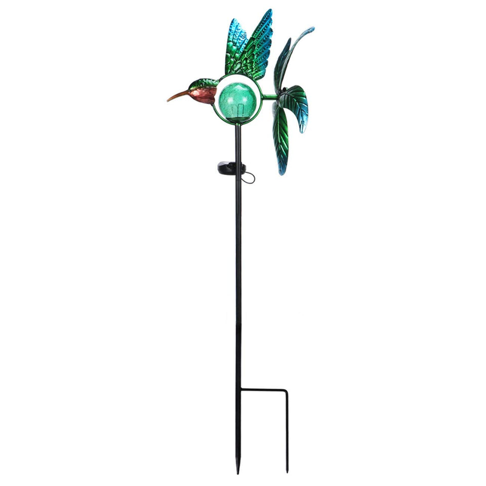Afirst solar hummingbird wind spinner glows at night while turning in daylight