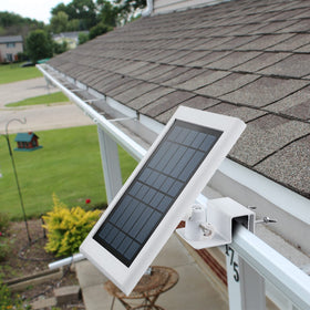 White finished bracket blends with gutters while supporting Ring solar panels outdoors.