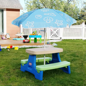 Kids enjoy shaded picnic at a small table under AMMSUN umbrella.