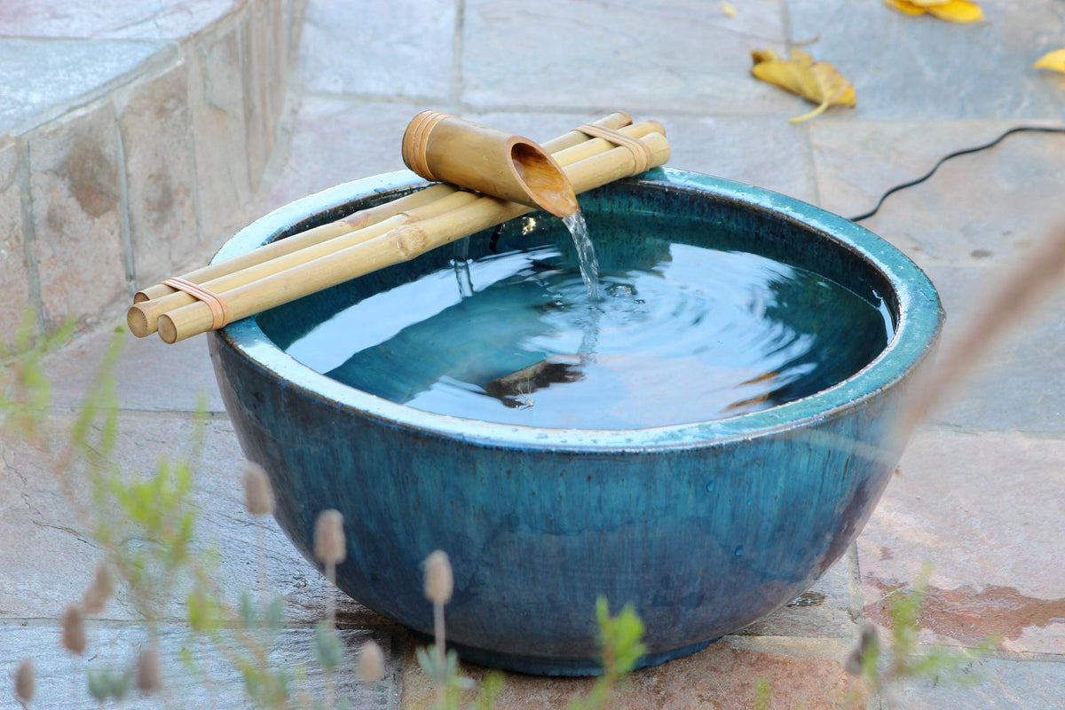 Outdoor garden bowl fountain setup with rim placement and stabilizing stones.