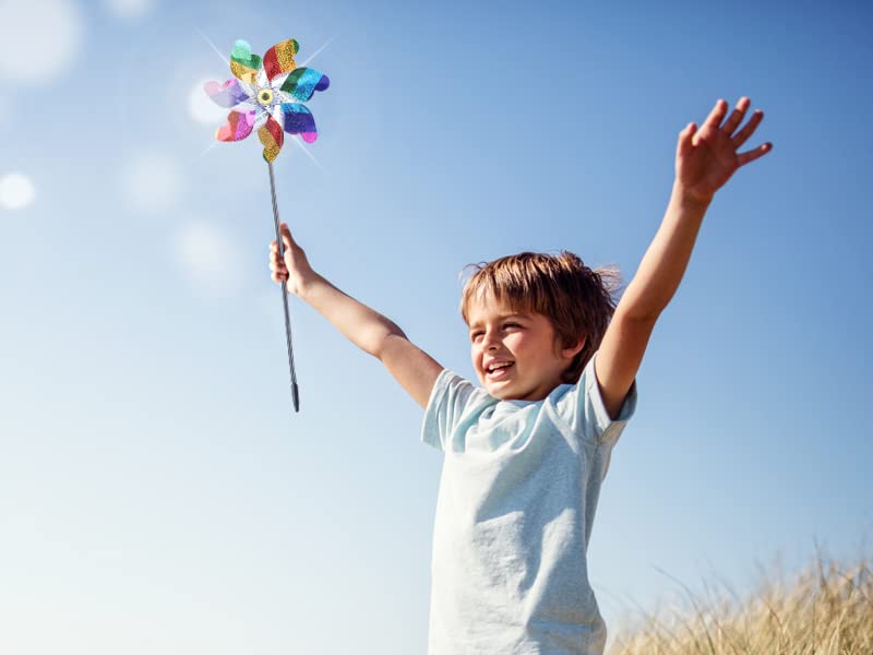 Bright rainbow-colored wind spinner creating vivid light in garden