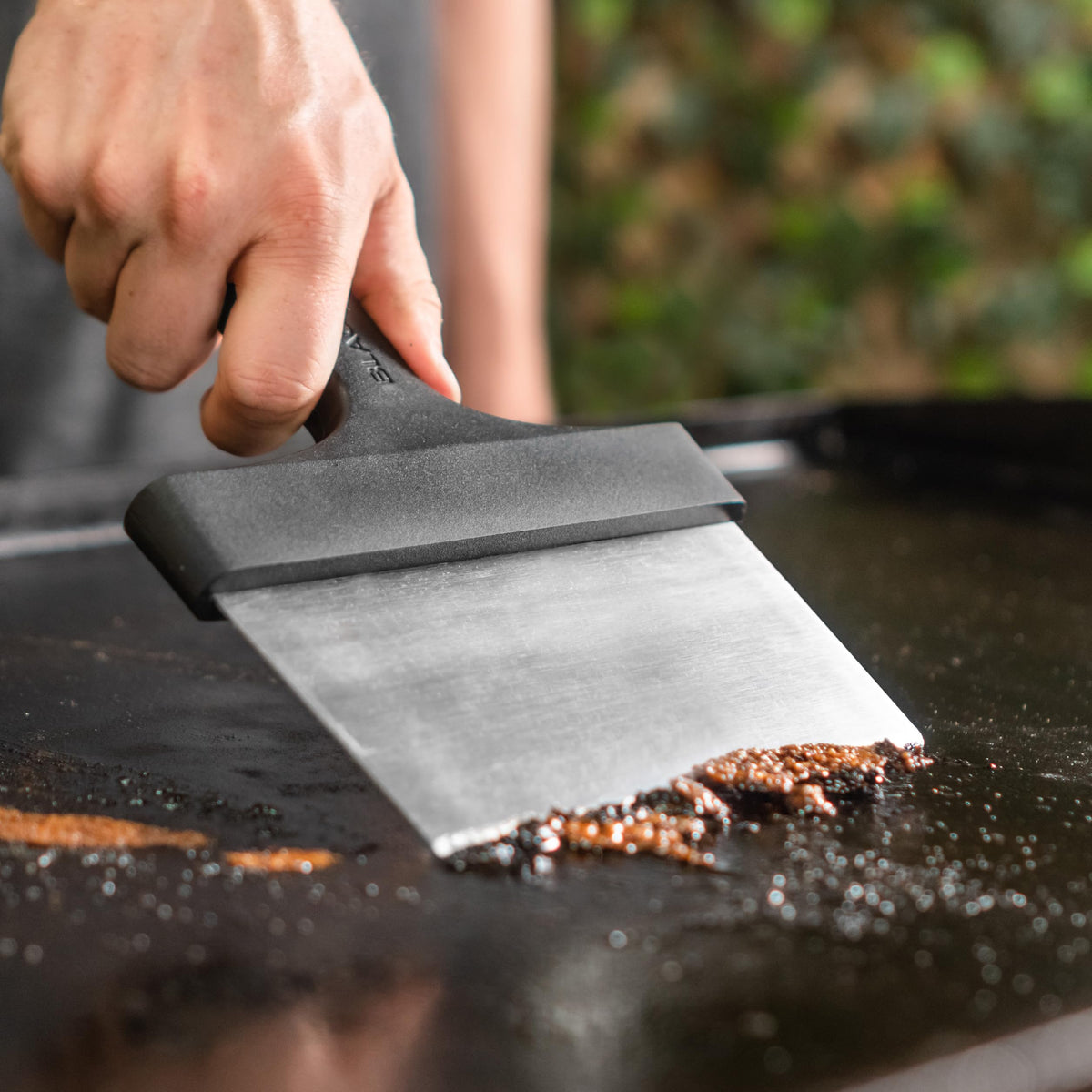 Blackstone griddle scraper with ergonomic handle for comfortable, controlled cleaning.
