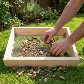 Bouticol wood dirt sifter being cleaned after soil screening to remove debris.