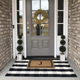 CAINANEL Buffalo Plaid Outdoor Rug on porch providing contrast and curb appeal