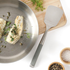 Calphalon Edge turner in use flipping food with controlled precision