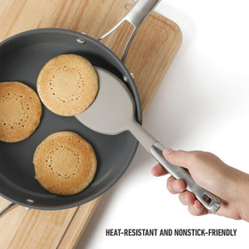 Heat-resistant silicone head flexes under heat while protecting cookware surfaces.