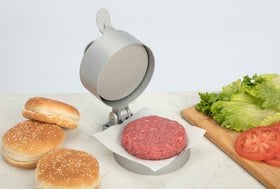 Cuisinart burger press lines with wax paper for neat patty transfer.