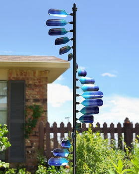 Cyan Oasis wind spinner with peacock spiral adding vibrant garden color