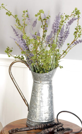 Deco 79 watering can with fleur-de-lis embossing adds classic garden decor appeal.