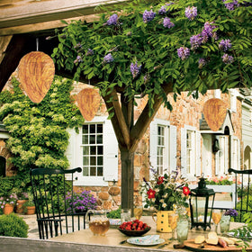 DECYOOL orange nest decoy over garden trees activates visual deterrence for gatherings.