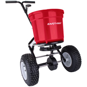 EarthWay 2150 spreader on turf with tires gliding over uneven ground for precise application