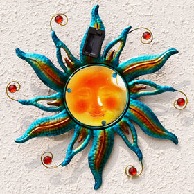 Fashionoda solar sun face wall art in blue, ideal garden focal point at dusk.