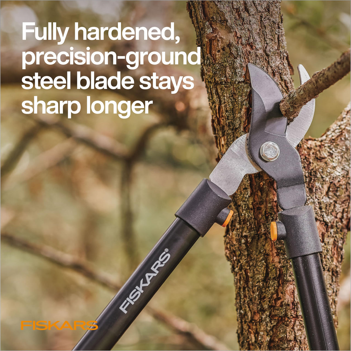 Fiskars bypass lopper in action cutting green branches with smooth, efficient motion.