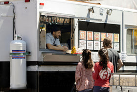 Flame King 100lb tank on a food truck for grilling.