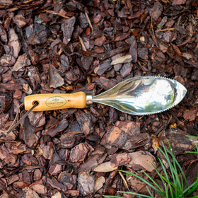 Garden Works Original Soil Scoop dirt cradle holding soil for cleaner planting holes.