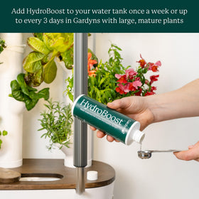 Gardyn HydroBoost tank-dilution scene; demonstrates a simple weekly maintenance step.