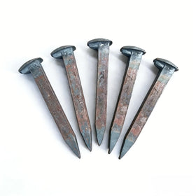 Generic railroad spikes arranged in a row for forging and DIY projects.