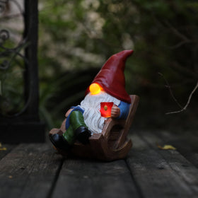 Generic solar garden gnome chair light glowing at dusk for outdoor charm