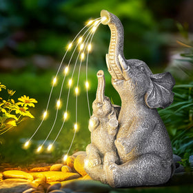 GIGALUMI solar elephant statue front-lit enhances nighttime garden ambiance.