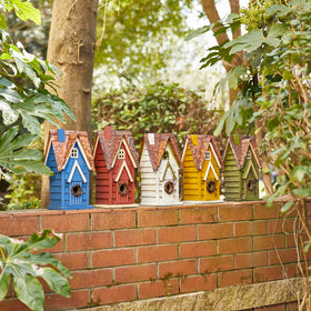 Glitzhome green bird house in garden setting enhances natural ambiance.