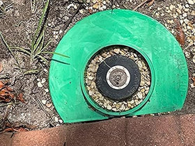 GRASSHOLE donut-style protector guards sprinkler heads for easier lawn maintenance.