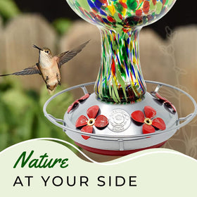 Grateful Gnome hummingbird feeder close-up, red speckled mushroom glass enhances outdoor color