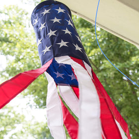 Homarden windsocks frame outdoor parties with bold red, white, and blue motion.