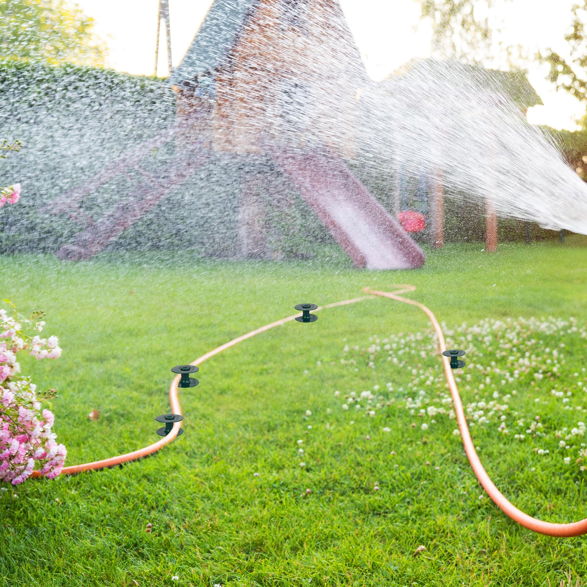 Hourleey garden hose guide assembly shown in yard setting.