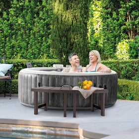 Intex PureSpa bench in use beside towels and drinks for spa convenience