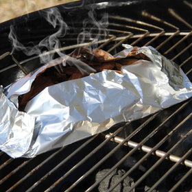Ribs on the grill boosted by whiskey barrel smoke.