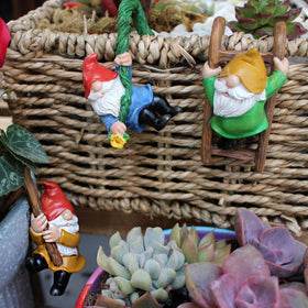 JARPSIRY gnome with branch creates a whimsical focal point for planters.