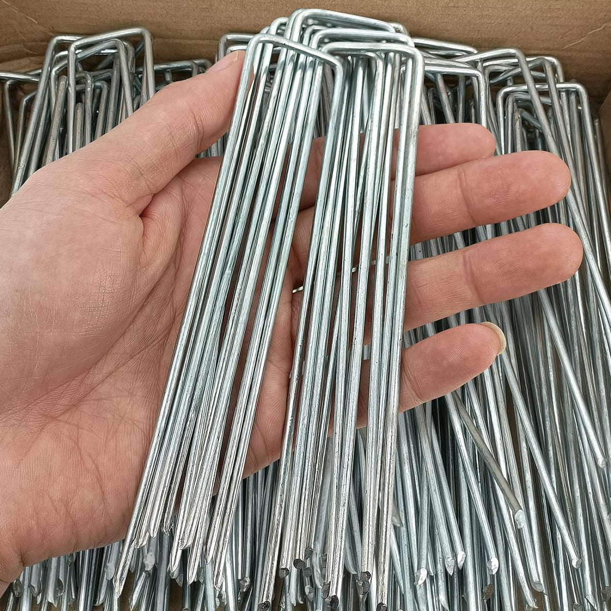 Jxrhy garden staples securing landscape fabric into the ground for stable setups.