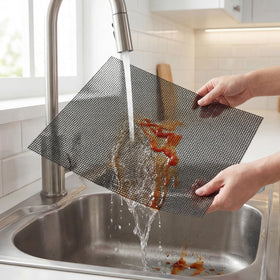 Kingrol mesh mat on a gas grill with vegetables cooking evenly