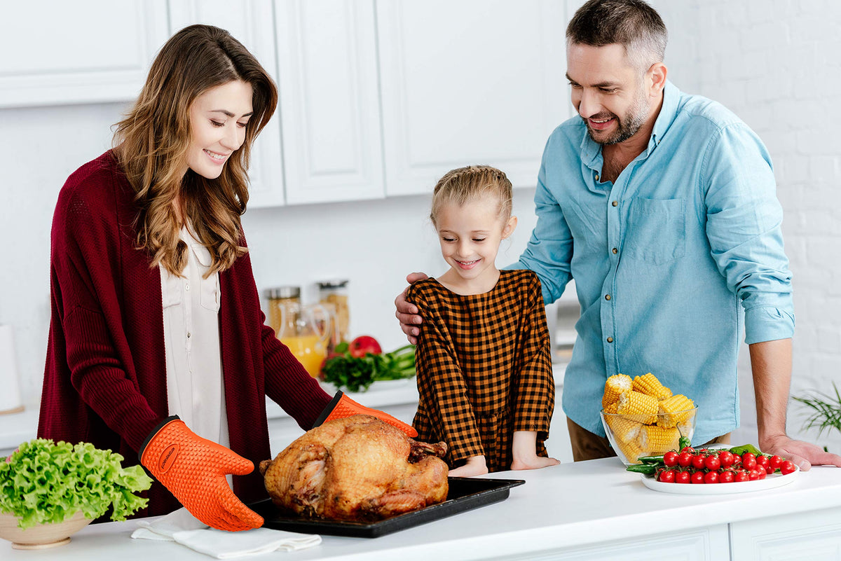 Kitchen Perfection durable gloves with reinforced cuff demonstrated while lifting a heavy pan