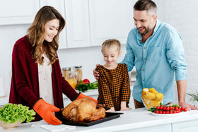 Kitchen Perfection durable gloves with reinforced cuff demonstrated while lifting a heavy pan