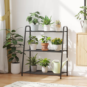 Kitsanery black metal stand blends with decor and keeps plants organized.