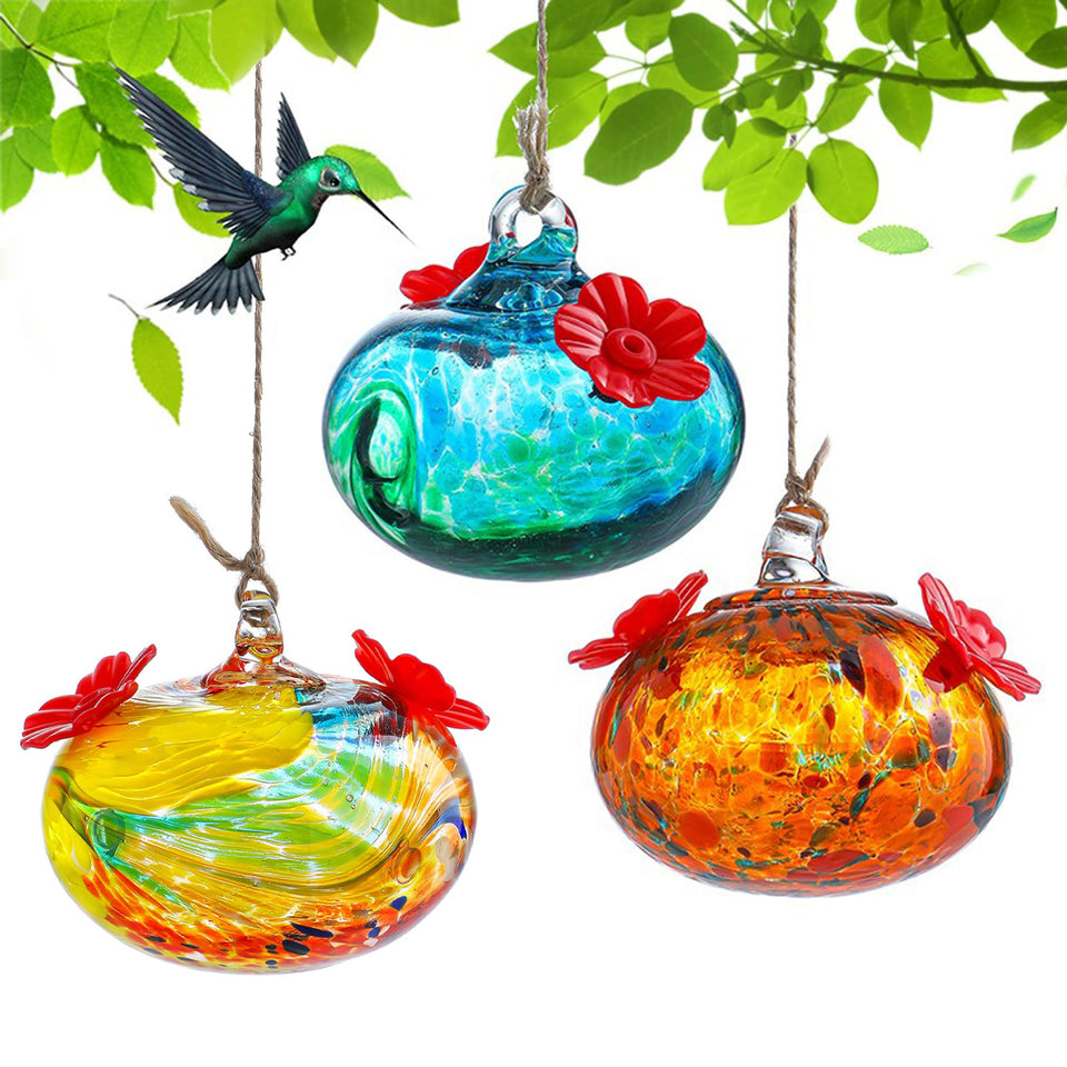 KRISININE three-pack hand-blown glass hummingbird feeders attract hummingbirds outdoors.