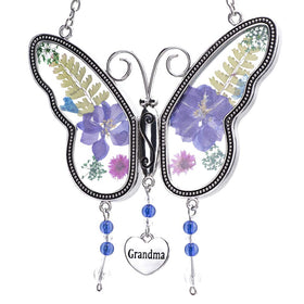 Laraine butterfly suncatcher with pressed flowers brightens a sunlit window.