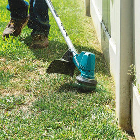 Makita XRU23Z in-use trimming edges in a well-kept yard.
