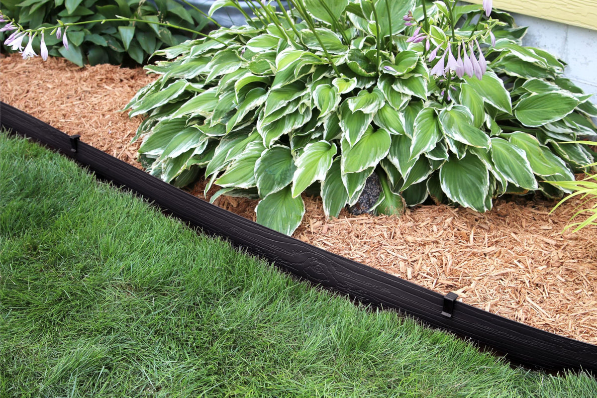Master Mark terrace board wood-grain finish blends naturally with paths and beds.