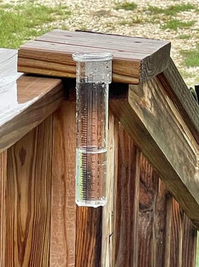 Mateda rain gauge shown mounted on a deck or fence post for easy setup.