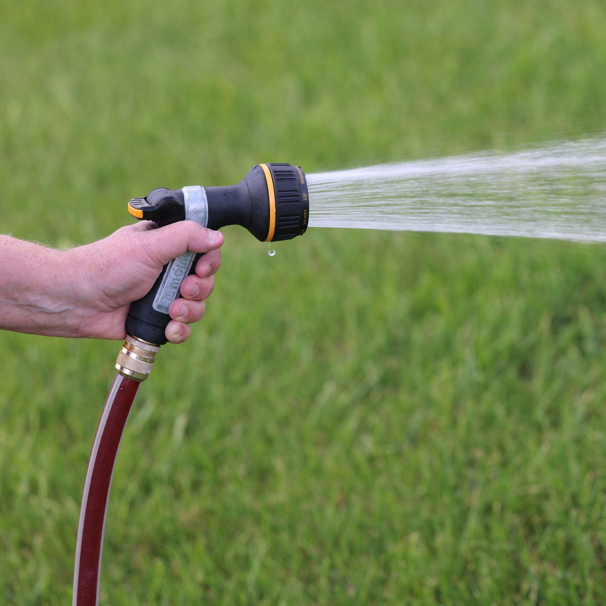Melnor thumb-control nozzle showing ergonomic, slip-resistant grip for comfortable watering.