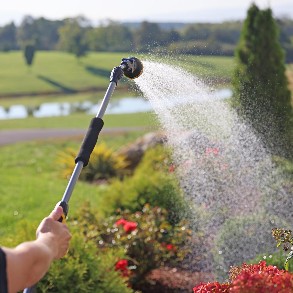 Melnor user waters hanging plants with extension wand for convenient overhead irrigation