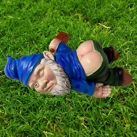 MINICAR gnome lying on the ground, one eye open, adds playful charm to yard.