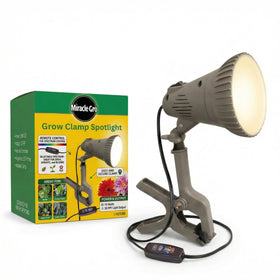 Miracle-Gro indoor grow light clamp spotlight illuminating houseplants.