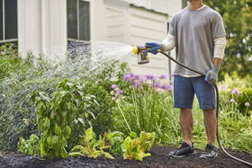 Hose sprayer attachment enables simple feeding while watering outdoor beds.