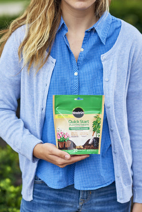 Dropping Miracle-Gro tablets into the root ball promotes initial nutrition